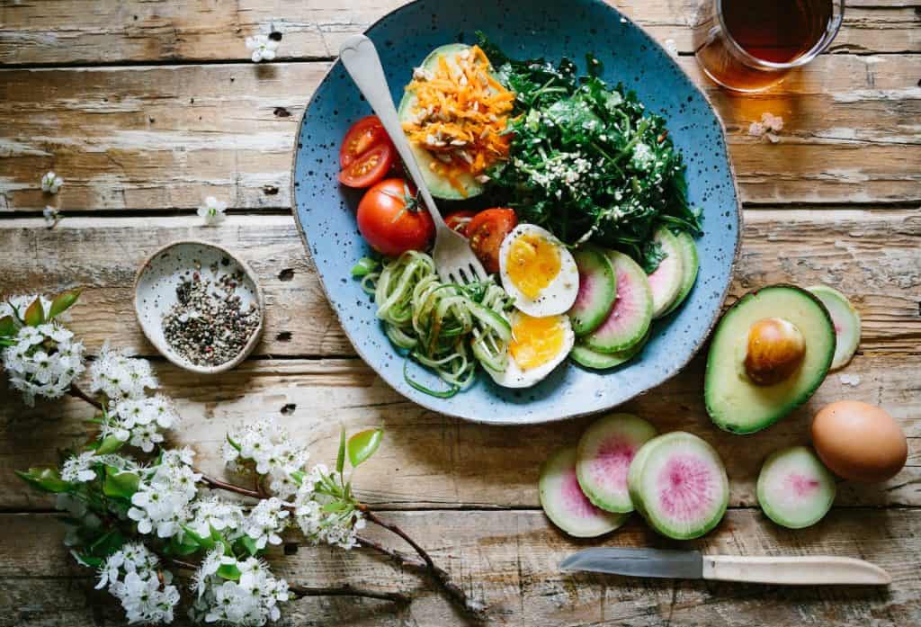 Mediterranean Diet - poached egg with vegetables and tomatoes on blue plate