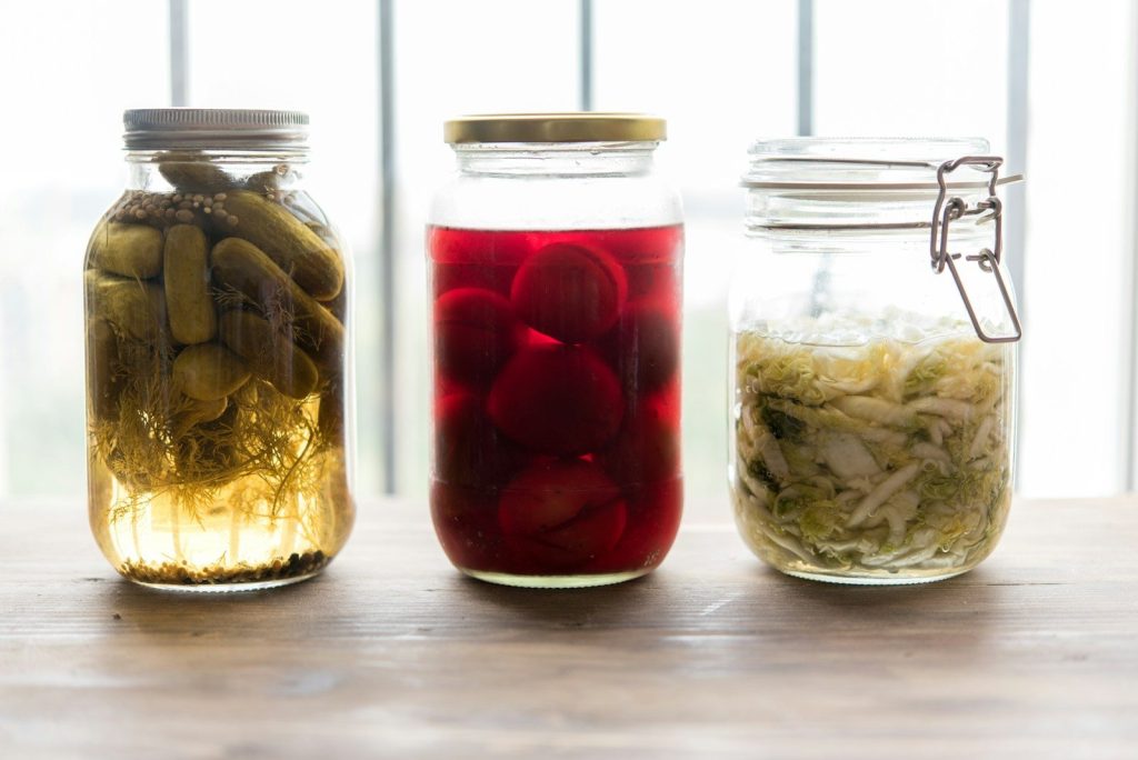 three jars filled with different types of Fermented Foods.
