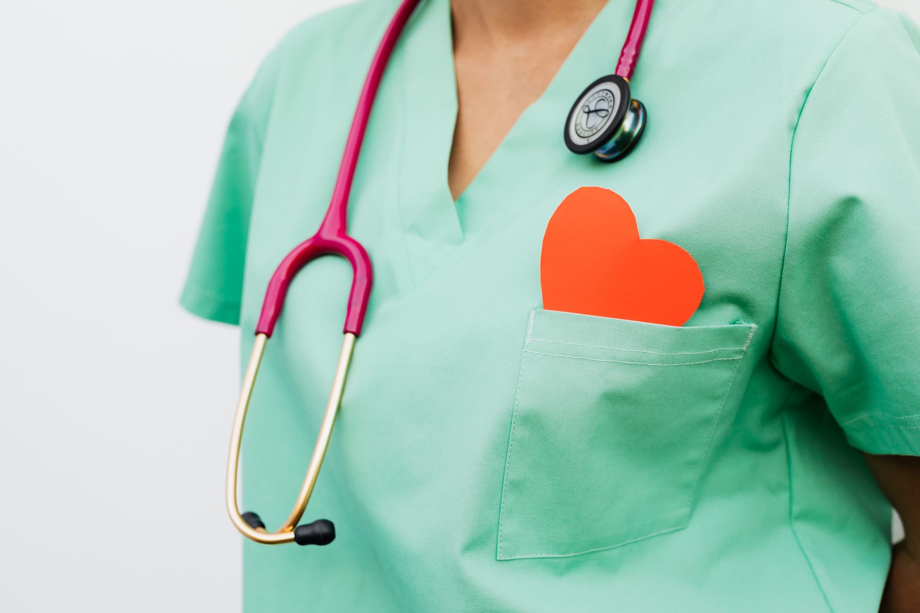 Healthcare professional with stethoscope and red heart symbol representing cardiology care