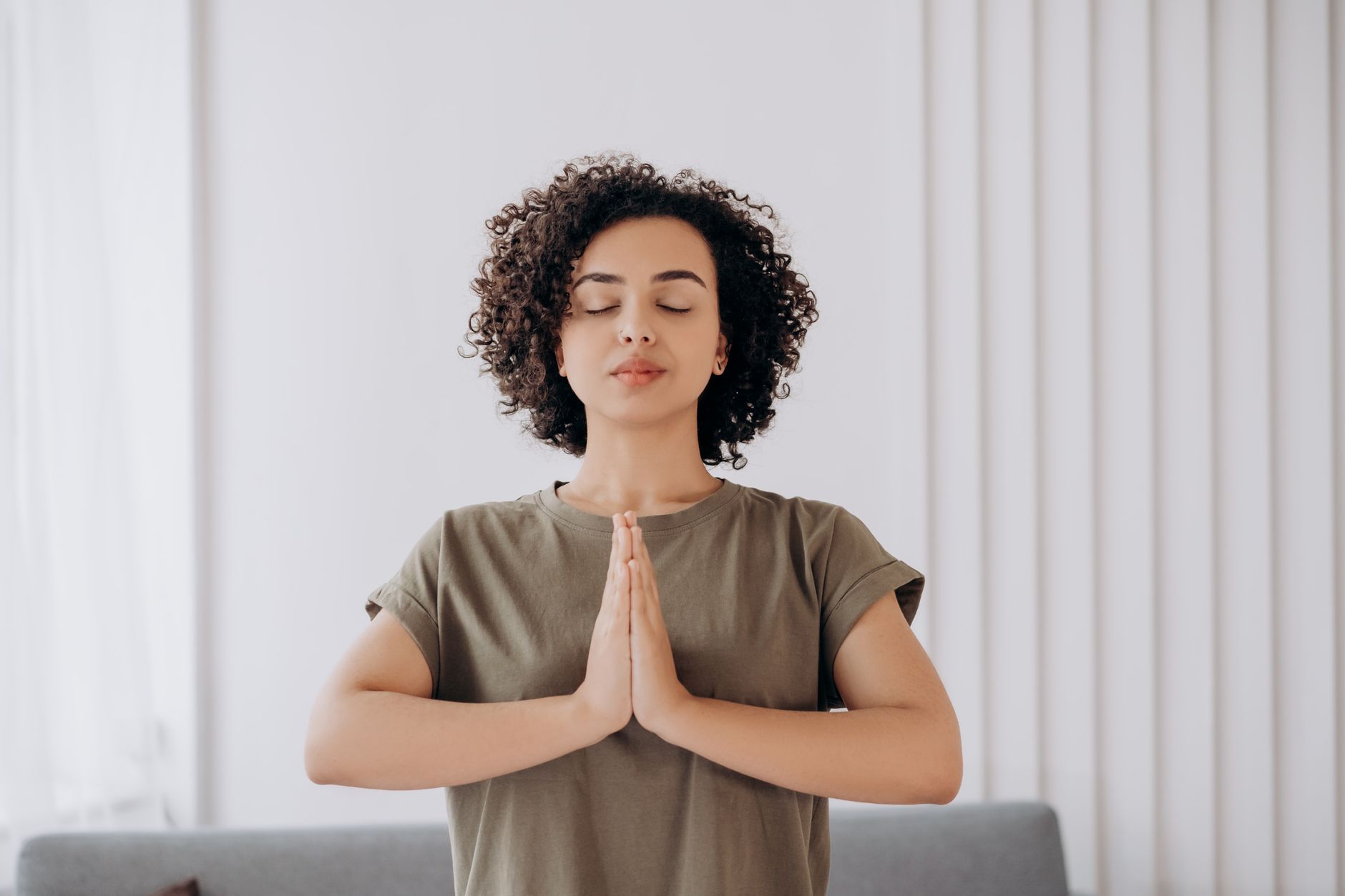 Woman meditating indoors practicing mindfulness to manage stress
